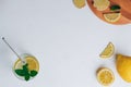 Glass with lemonade with metal straw. Ginger, lemon, mint on white surface. Wooden tray. Top view. Copy space Royalty Free Stock Photo