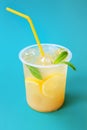 A glass with lemonade or mojito cocktail with lemon and mint, cold refreshing drink or beverage with ice on blue Royalty Free Stock Photo