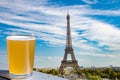 Glass of light beer against Paris skyline with Eiffel tower background Royalty Free Stock Photo