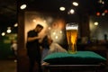 Glass of light beer in a dark barbershop