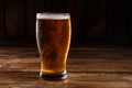 Glass of light beer on a dark pub. Glass beer on wood background with copy space Royalty Free Stock Photo