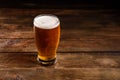 Glass of light beer on a dark pub. Glass beer on wood background with copy space Royalty Free Stock Photo