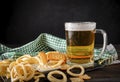 Glass  of light beer with onion rings and cracker on a dark background alcoholic drink with snacks Royalty Free Stock Photo