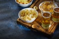 A glass of light beer, onion rings, snacks, chips. Dark blue background. Rest, relaxation, watching your favorite TV shows and Royalty Free Stock Photo