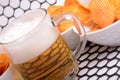 Glass of light beer and potato chips on a abstract background Royalty Free Stock Photo