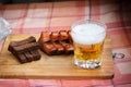A glass of light beer with smoked fish and black fried bread in garlic. Beer and beer snack on a wooden Board Royalty Free Stock Photo