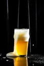 Glass of light beer with a thick foam, beer, splash, black background. vertical image. place for text Royalty Free Stock Photo