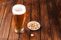 glass of light cold frothy beer, nuts old wooden table Royalty Free Stock Photo