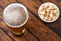 glass of light cold frothy beer, nuts old wooden table Royalty Free Stock Photo