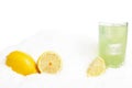 Glass of lime juice with ice cubes,lemons on snow on white Royalty Free Stock Photo