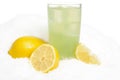 Glass of lime juice with ice cubes,lemons on snow on white Royalty Free Stock Photo