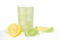 Glass of lime juice with ice cubes,limes and lemons halves on snow on white Royalty Free Stock Photo