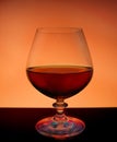 Glass with liquid on brown-orange background