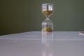 Glass made sand timer on table Royalty Free Stock Photo