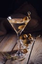 Glass of martini with green olives on a old wooden table Royalty Free Stock Photo