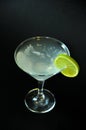 A glass of martini with ice and a slice of lime on the edge, composition on a black background Royalty Free Stock Photo