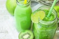 Glass Mason Jar and Bottle with Green Vegetable and Fruit Smoothie and Juice with Straw. Basket with Seasonal Organic Produce