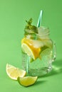 Homemade sparkling lemonade with ice, slices of lime and lemon, leaf of mint with plastic straws in a mason jar on a Royalty Free Stock Photo