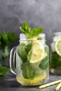 Glass mason jar of ice tea with fresh mint, lemon and paper straw on dark background. Summer healthy cold drink. Alternative Royalty Free Stock Photo