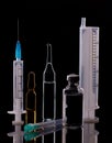 Glass medical ampoules and syringe. Black background. Viral vaccination