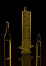 Glass medical ampoules, vials, syringe. Black background. Viral vaccination and social health