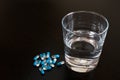 Glass with medicine capsules on the table Royalty Free Stock Photo