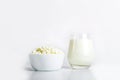 Glass of milk and bowl with homemade cottage cheese on a white background. The concept of healthy dairy products with calcium. Royalty Free Stock Photo