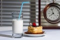 Glass of milk, cake and watch on a table. Breakfast. Royalty Free Stock Photo