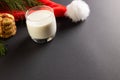 Glass of milk, christmas cookies and santa hat with copy space on black background Royalty Free Stock Photo