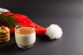 Glass of milk, christmas cookies and santa hat with copy space on black background Royalty Free Stock Photo