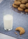 A glass of milk and a cookie with a bite taken out of it sit on Royalty Free Stock Photo