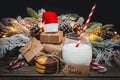 A glass of milk, cookies, santa hat and gifts on the table. Royalty Free Stock Photo