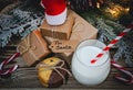 A glass of milk, cookies, santa hat and gifts on the table. Royalty Free Stock Photo