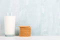 A glass of milk and cookies on the table, on a blue background, minimalism. Copy space Royalty Free Stock Photo
