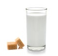 Glass of milk and cubes of cane sugar on white backgrou