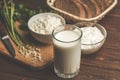 Glass of milk, curd in bowl, cheese cream, fresh bred and green herb on wooden cutting board as ingredients