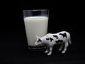 Glass of milk with dairy cow. Milk cow. Black and white cow with spots. Spotted cow. Ruminant farm animal. Drink. Milk. Toy cow. I