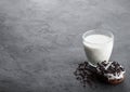 Glass of milk and doughnut with black cookies on black stone kitchen table background. Space for text. Royalty Free Stock Photo