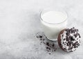 Glass of milk and doughnut with black cookies on stone kitchen table background. Space for text Royalty Free Stock Photo