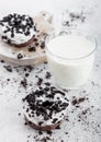 Glass of milk and doughnuts with black cookies on stone kitchen table background. Space for text. Royalty Free Stock Photo