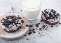 Glass of milk and doughnuts with black cookies on stone kitchen table background. Space for text Royalty Free Stock Photo