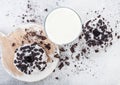 Glass of milk and doughnuts with black cookies on stone kitchen table background. Space for text. Top view Royalty Free Stock Photo