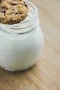 Glass of milk and homemade sugar cookies with colorful chocolate candies on a wooden board. Royalty Free Stock Photo