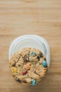 Glass of milk and homemade sugar cookies with colorful chocolate candies on a wooden board. Royalty Free Stock Photo