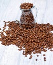 Glass milk jug and coffee beans Royalty Free Stock Photo