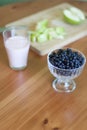 A glass of milk, a plate of apples, a bowl of blueberries on a green background Royalty Free Stock Photo