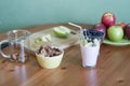 A glass of milk, a plate of apples, a bowl of blueberries on a green background