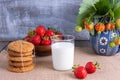 Glass of milk, ripe strawberries and cookies