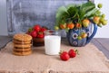 Glass of milk, ripe strawberries and cookies