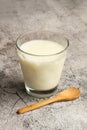 A glass of milk and a wooden spoon on a marble kitchencounter Royalty Free Stock Photo